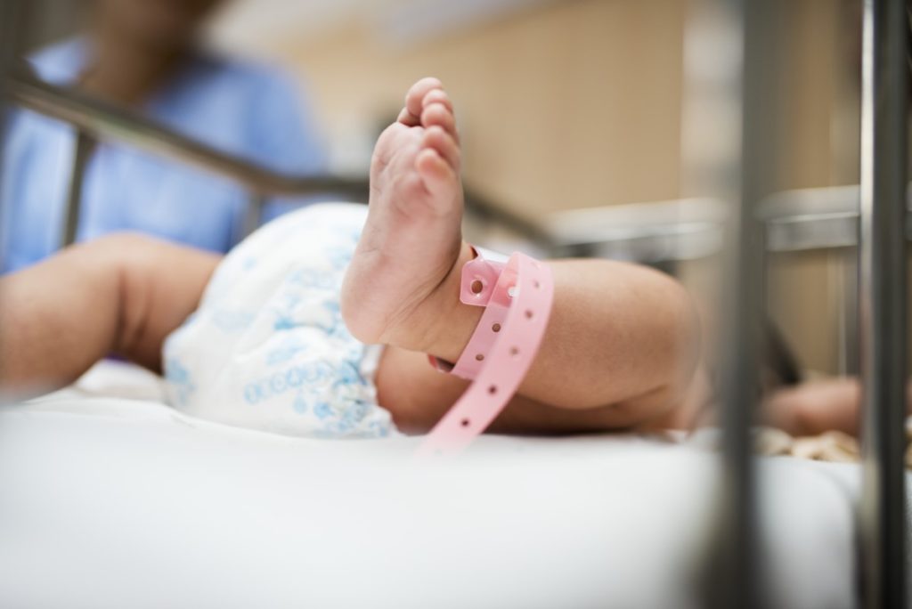 Imagem de bebê recém-nascido, com etiqueta em berçário de hospital