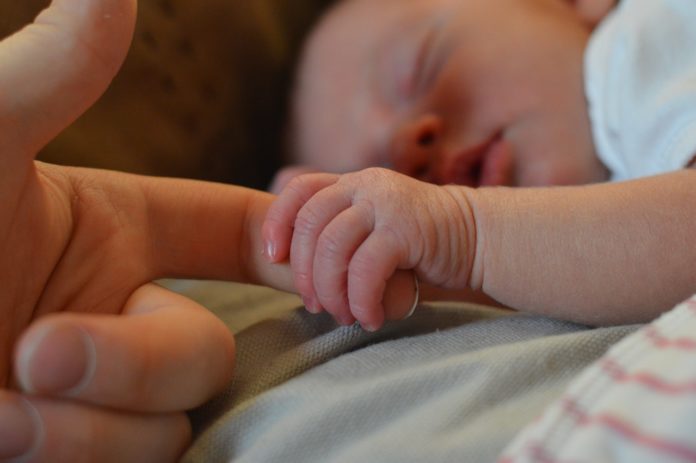 Imagem de mãe segurando a mão do seu bebê, presente no texto no blog da Sami sobre o tema: plano de saúde cobre parto com cesariana?