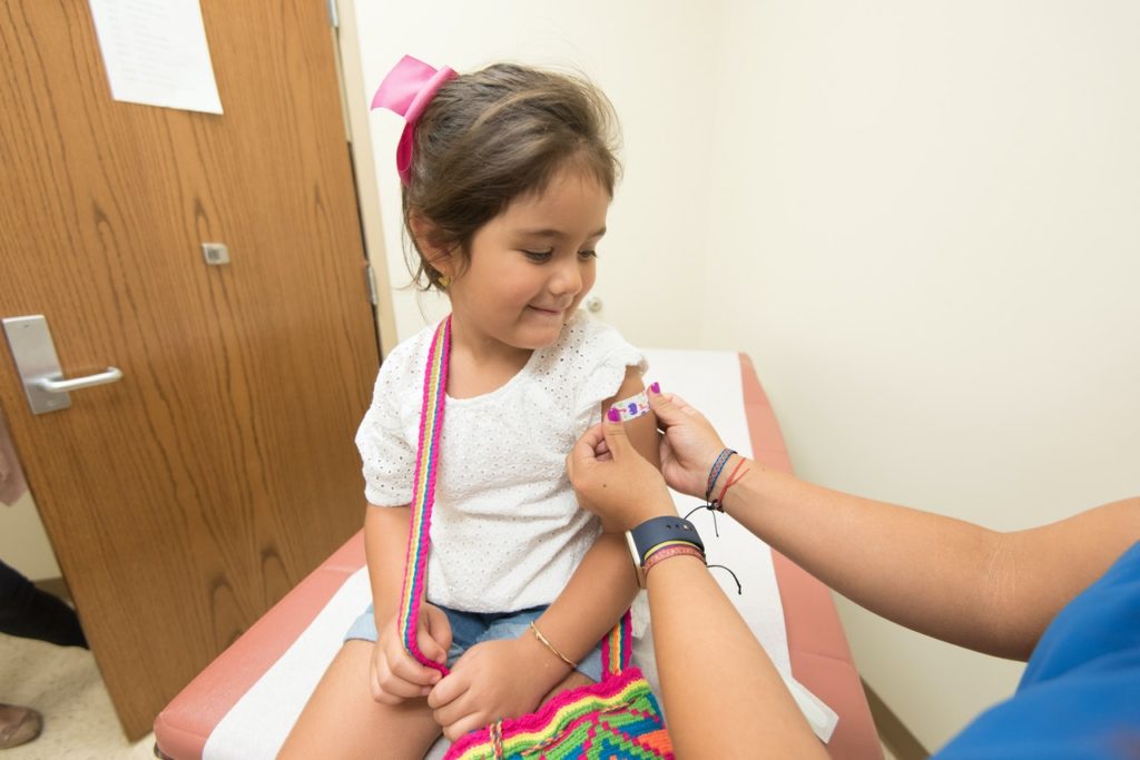 Imagem de criança recebendo curativo no braço, presente no texto que fala sobre o papel do técnico de enfermagem na atenção primária no blog da Sami