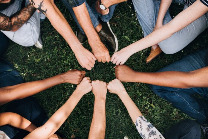 Imagem de time de colegas de trabalho unindo as mãos em sinal de união, presente no texto do blog da Sami que trata sobre motivação no trabalho e como o RH pode ajudar
