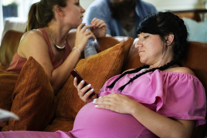 Imagem de jovem profissional grávida em momento de descontração com colegas de trabalho, presente no texto do blog da Sami que trata sobre os principais pontos que o RH deve conhecer sobre os direitos das gestantes no trabalho