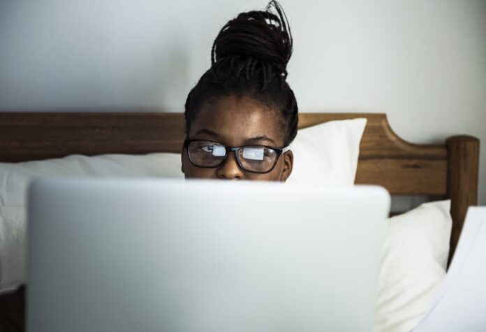 Imagem de empreendedora cansada trabalhando da sua cama, presente no texto do blog da Sami que trata sobre o excesso de trabalho e suas consequências para o empreendedor