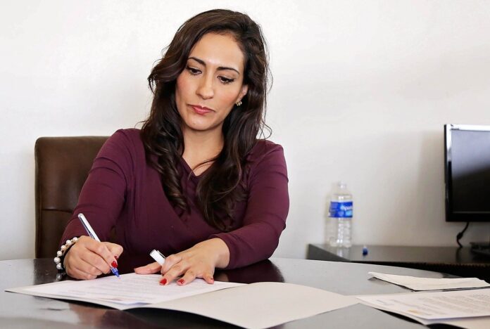 Imagem de mulher gerente de empresa assinando contrato, presente no texto sobre gestão de pessoas nas organizações e o impacto na qualidade de vida no trabalho no blog da Sami