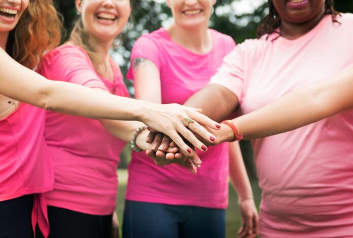 Mulherescom camisas cor de rosa de mãos dados