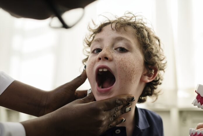 Imagem de criança mostrando sorriso em consultório de saúde dental, presente no texto do blog da Sami que trata sobre plano odontológico