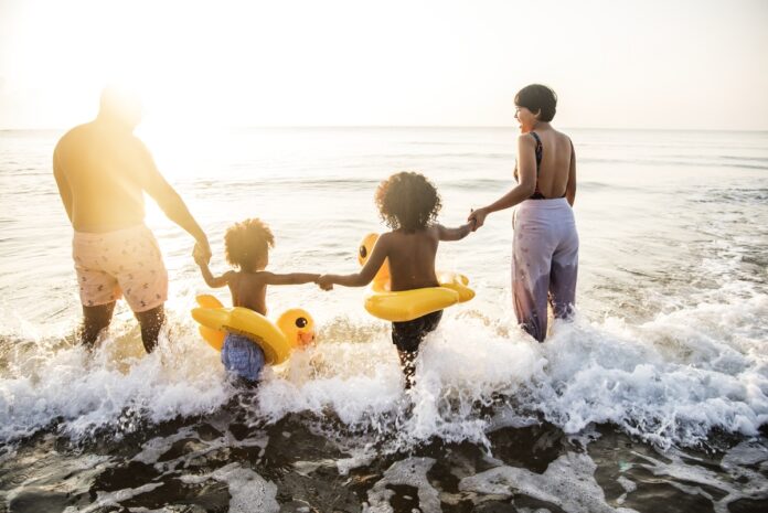 Imagem de família com pai, mãe e filhos na praia, presente no texto que trata sobre férias do colaborador e os pontos que o RH deve saber no blog da Sami