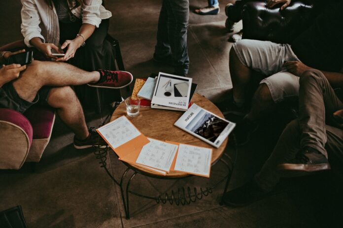 Imagem de time criativo sentado em café discutindo questões de trabalho, presente no texto do blog da Sami que trata sobre gestão de conflitos no trabalho e como fazer bem