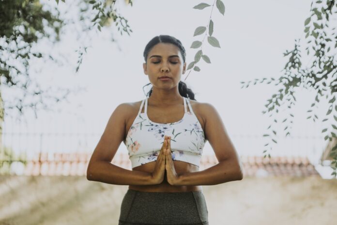 Imagem de jovem empreendedora meditando, presente no texto do blog da Sami que trata sobre a relação entre empreendedorismo e meditação