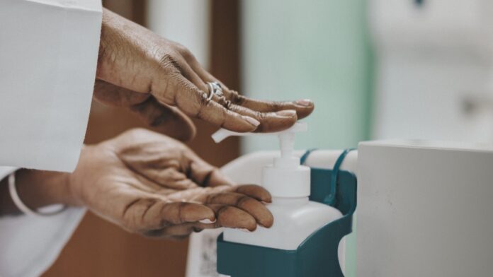 Imagem de mulher madura higienizando suas mãos com álcool em gel, presente no texto do blog da Sami que trata sobre a variante ômicron da COVID-19 e tudo o que se deve saber sobre este assunto