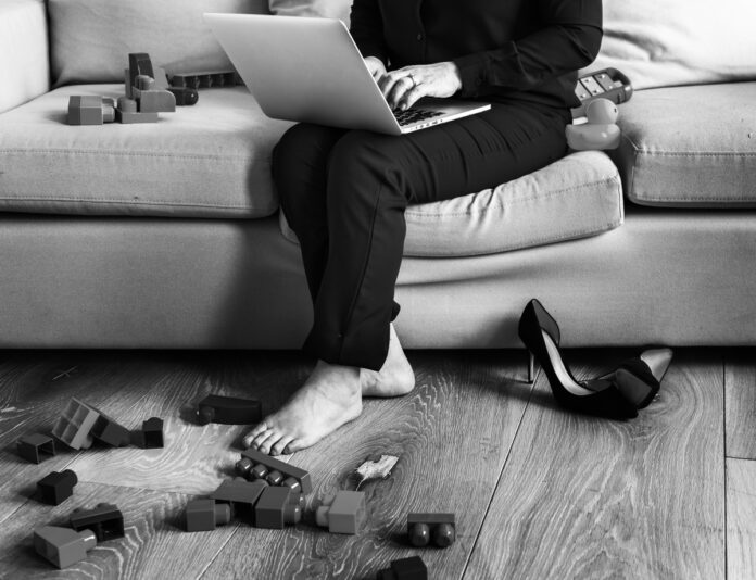 Imagem de mãe trabalhando enquanto os brinquedos da criança estão espalhados pela casa, presente no texto do blog da Sami que trata sobre mães no mercado de trabalho