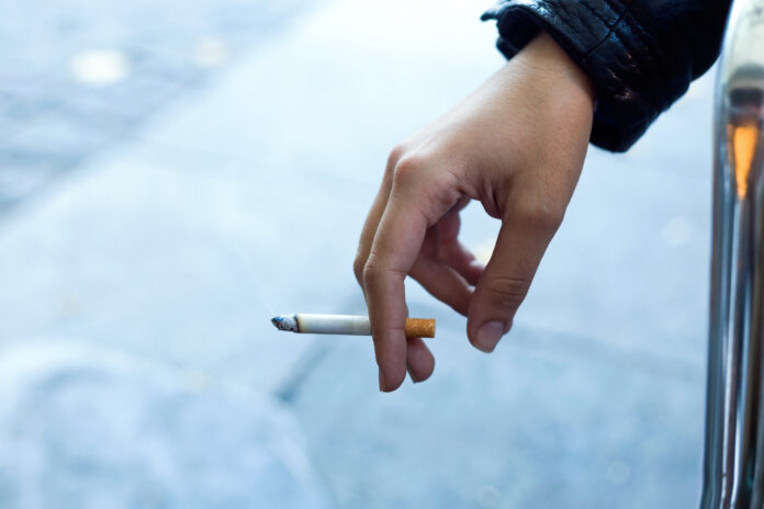 pessoa segurando cigarro acesso