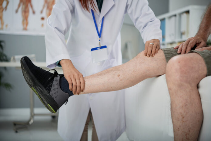 Médica analisando perna de paciente