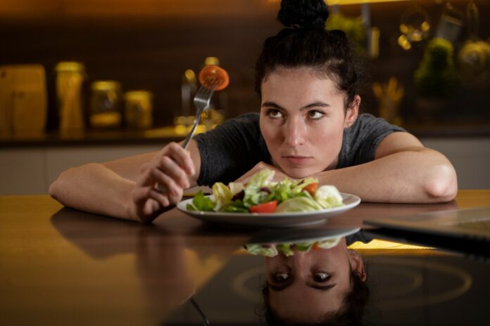 mulher observando prato de salada